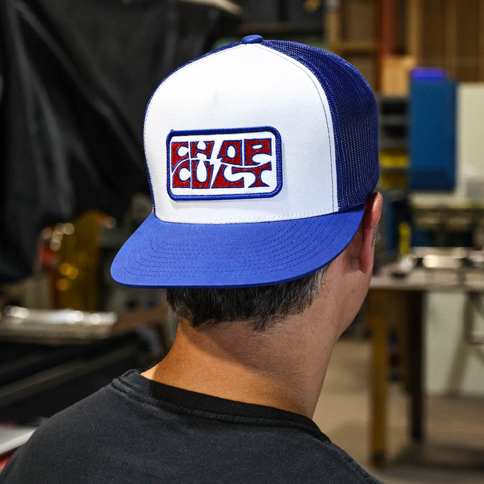 Person wearing a blue and white cap with a logo in an indoor setting