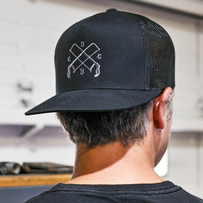 Person wearing a black cap with a logo, facing away from the camera.