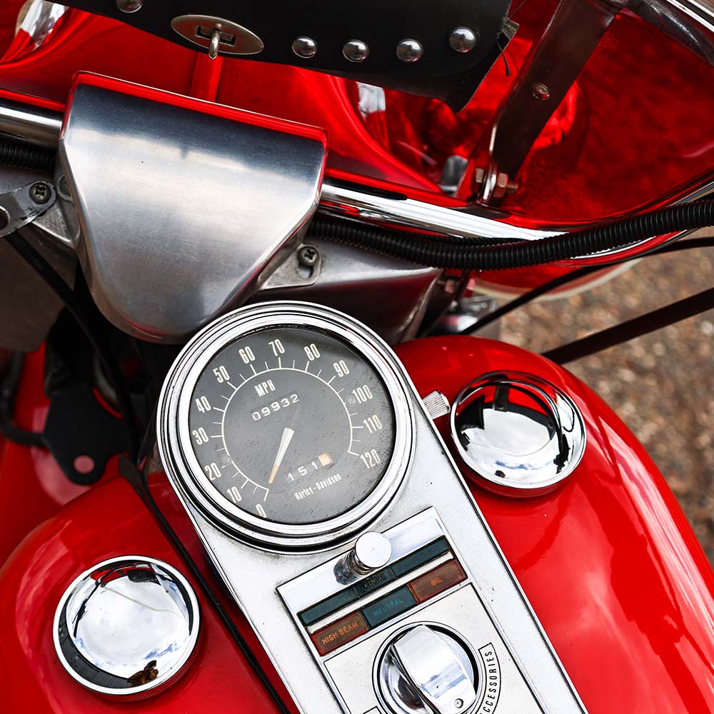 Close-up of a motorcycle's dashboard with a red background