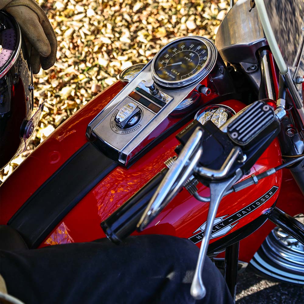 red motorcycle gas tank in front of leaves