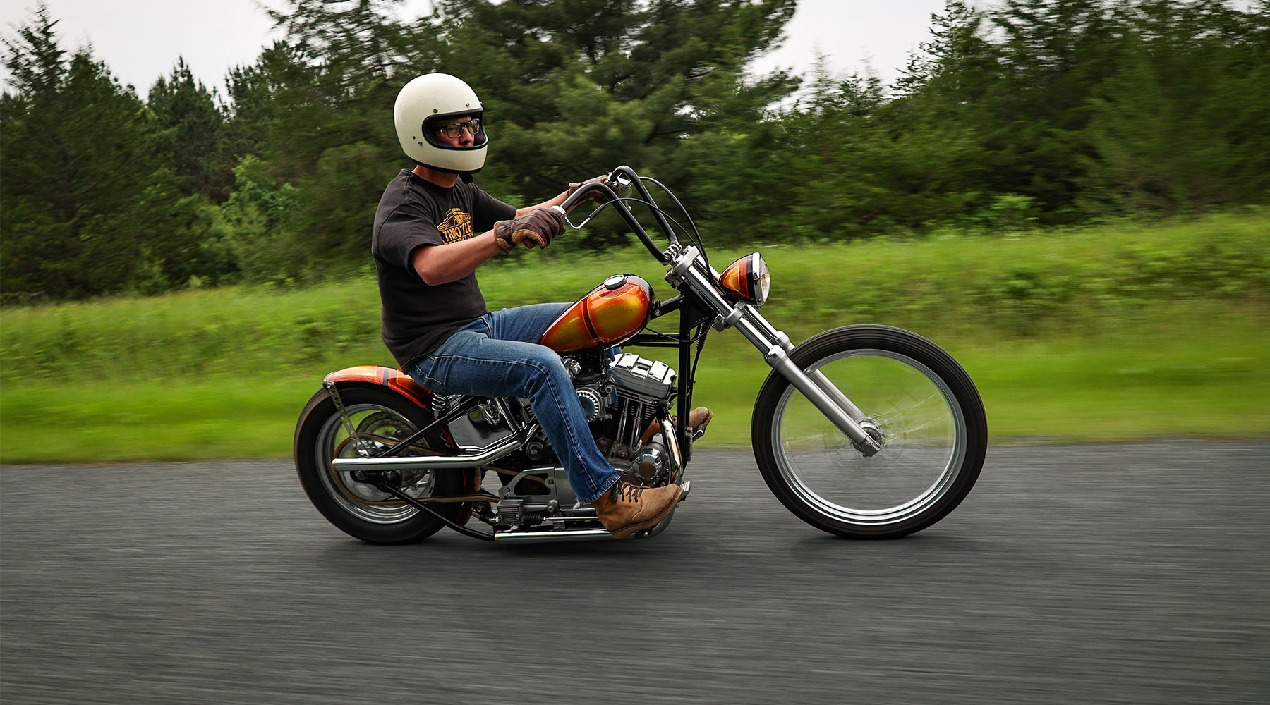 Man riding motorcycle in front of trees