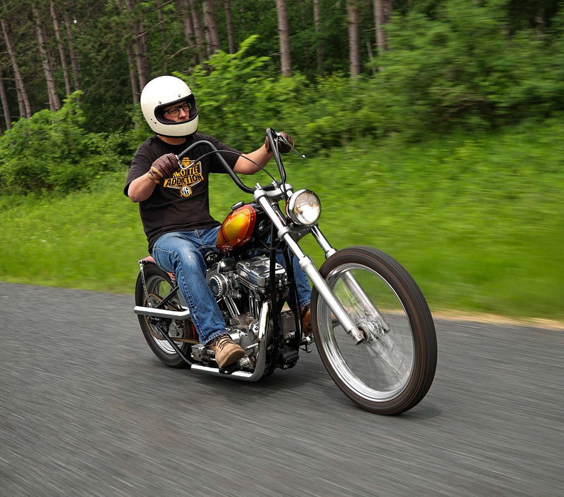 Man riding motorcycle in front of trees